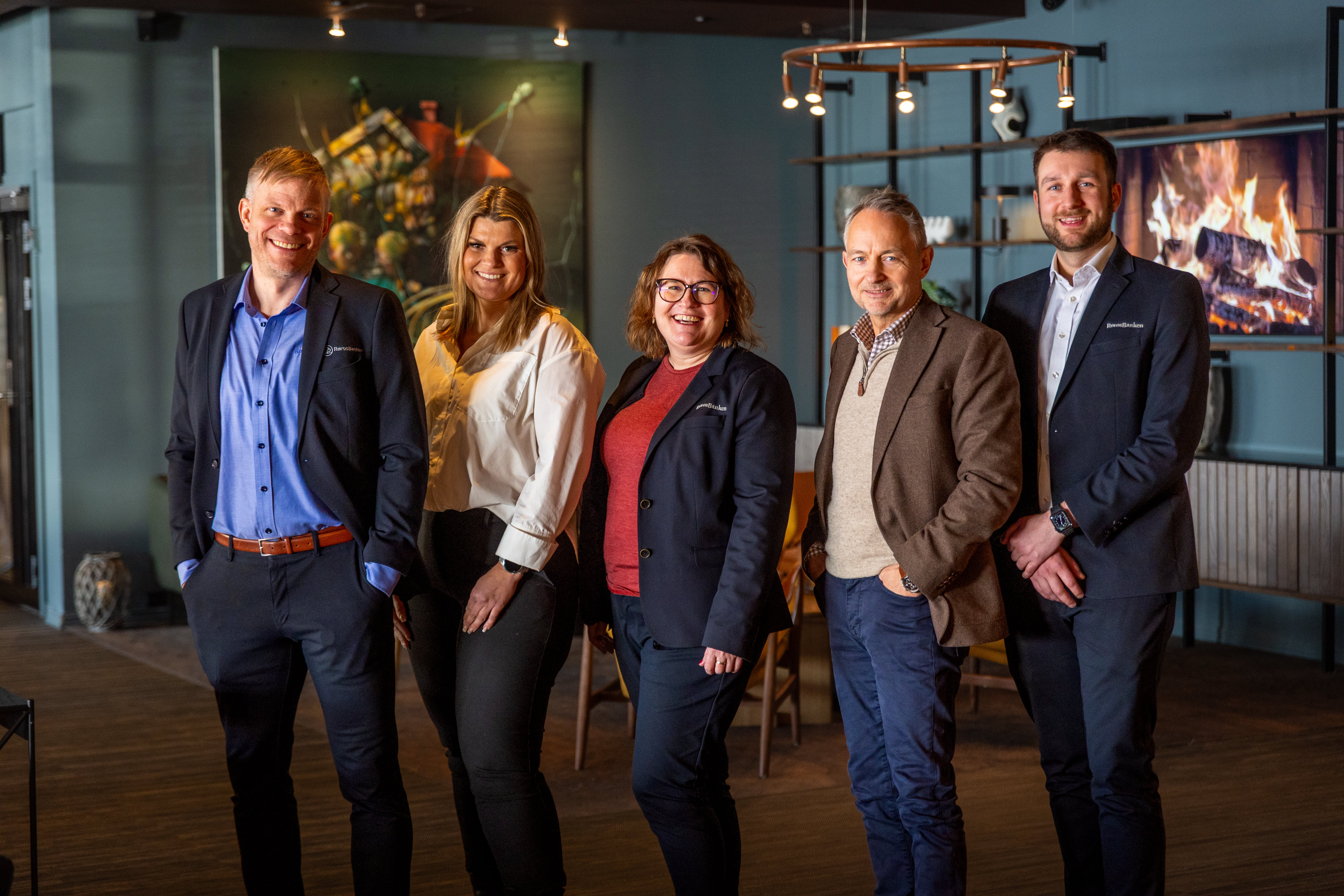 Bilde av fem bankrådgivere som står på rad og rekke i en hotellobby.