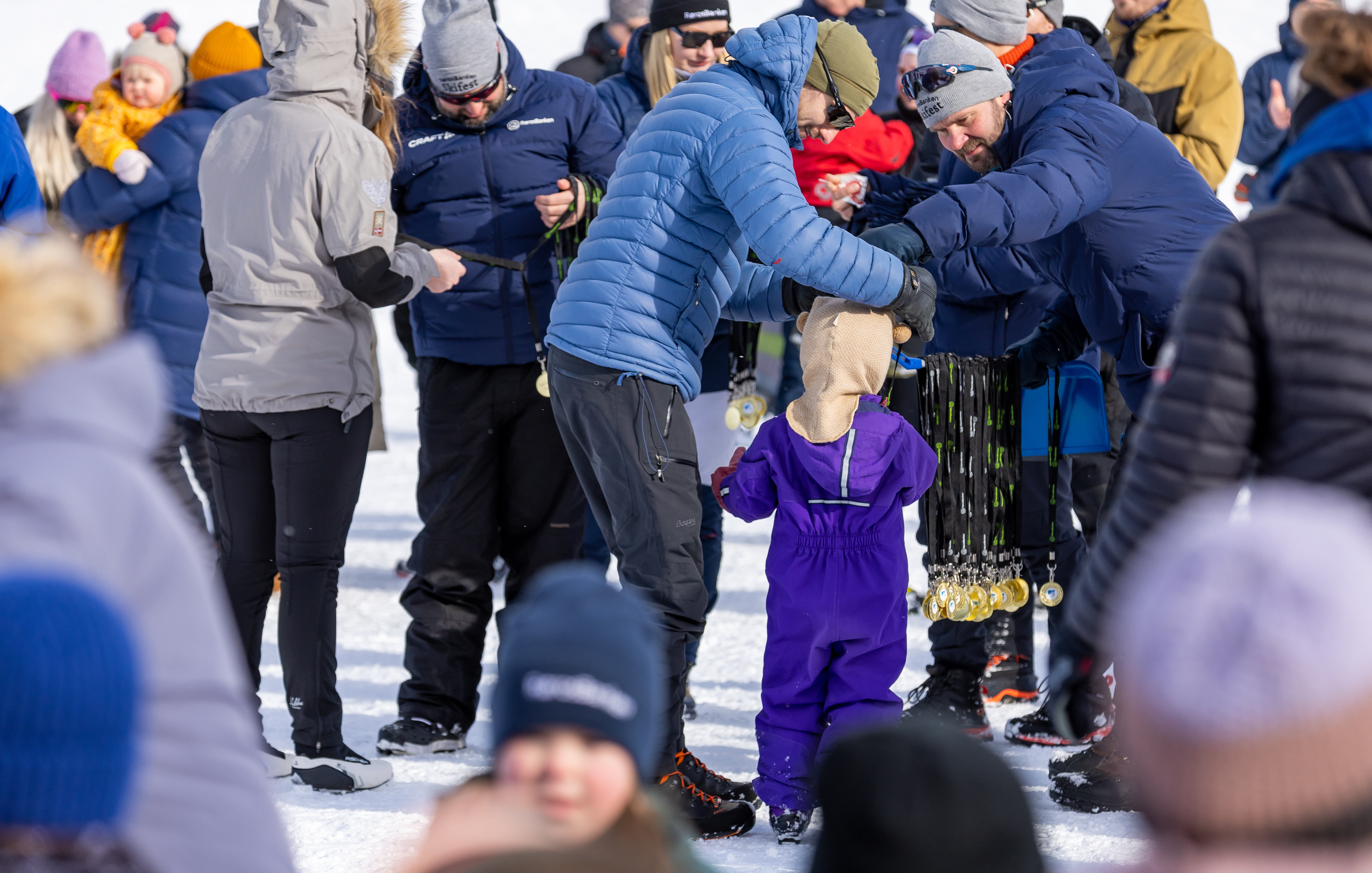 I en folkemengde, en mann som gir medalje til et lite barn