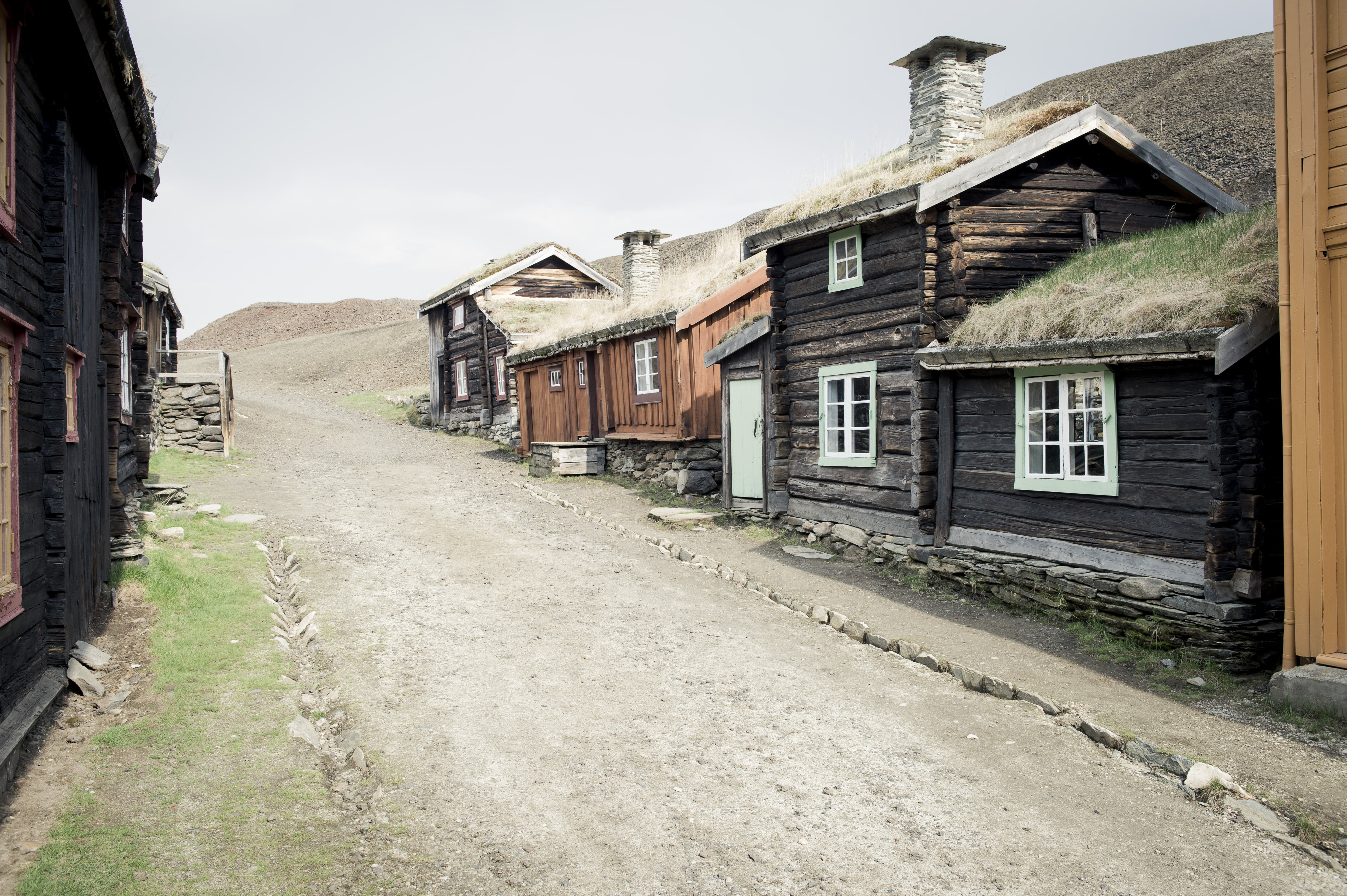 Bilde av en gammel gate på Røros, med gamle små tømmerhus. 