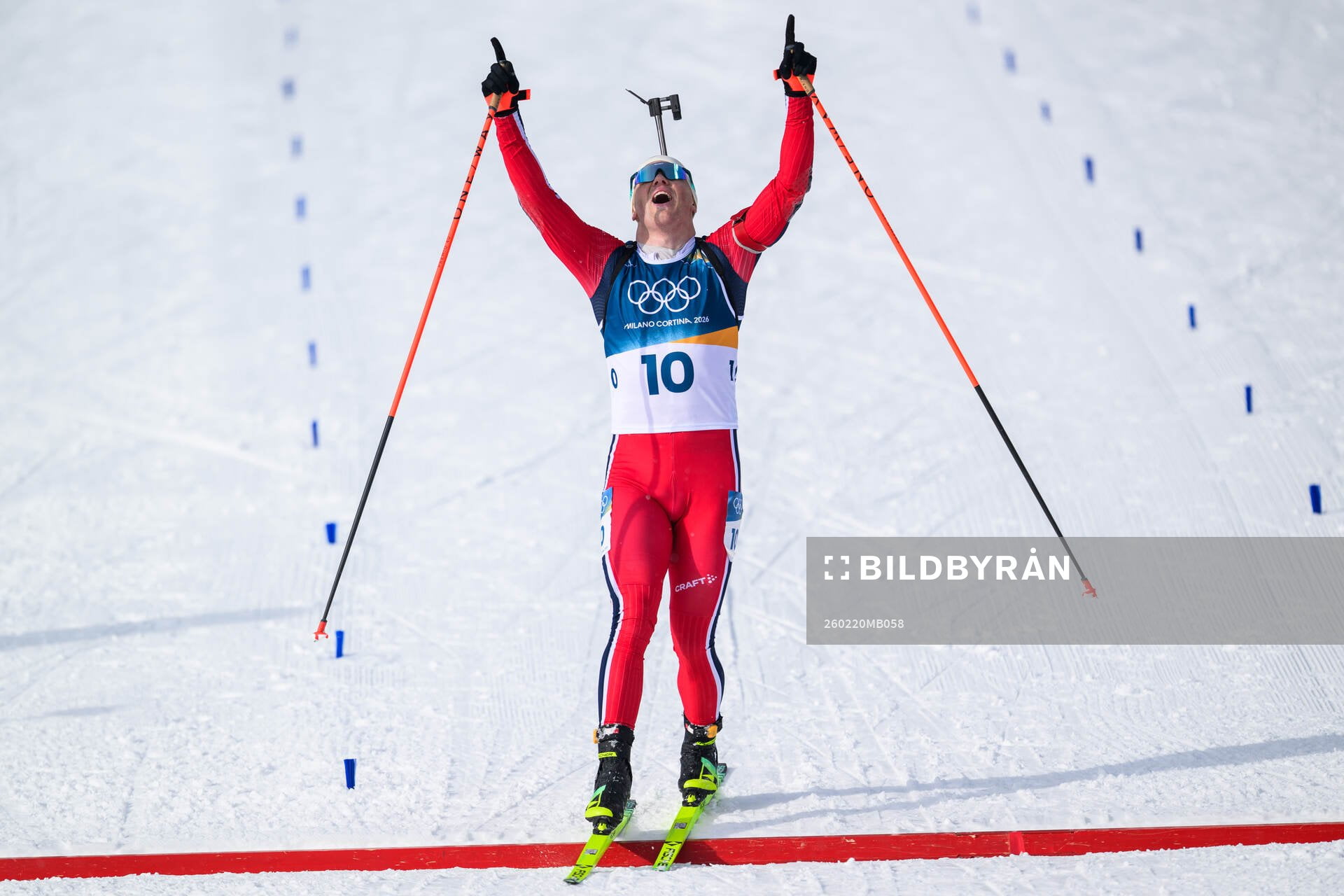 Johannes Dale-Skjevdal of Norway celebrates as he crosses the finish line in men's biathlon 15 km mass start during day 14 of the 2026 Winter Olympics on February 20, 2026 in Anterselva.